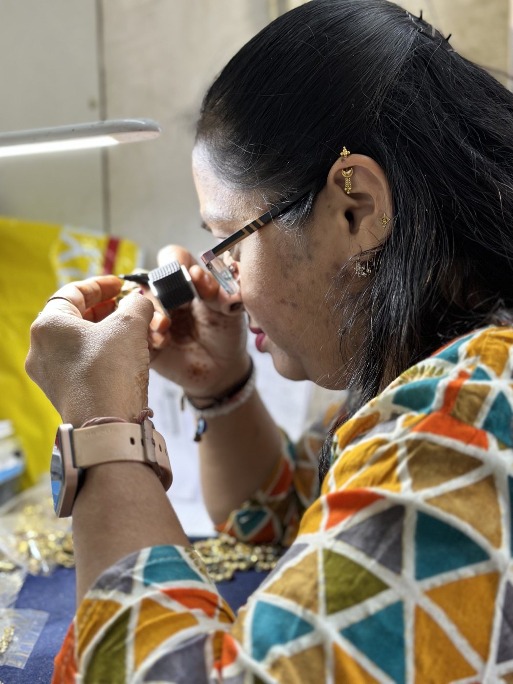 DVNJEWELRY quality inspector examining a gold piece through a loupe