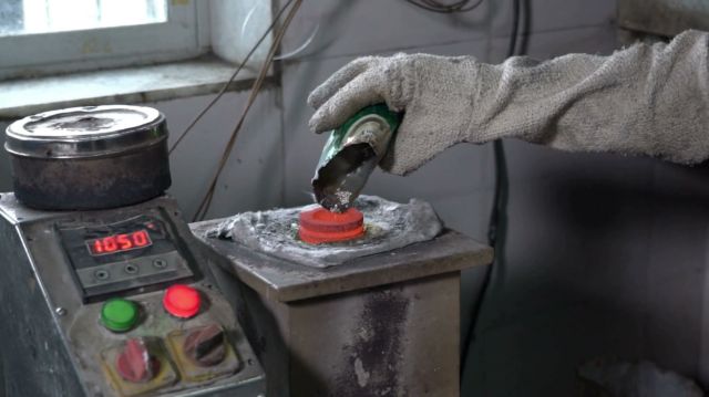 A casting technician pouring molten metal at 1,050°C into an investment flask (poster frame)